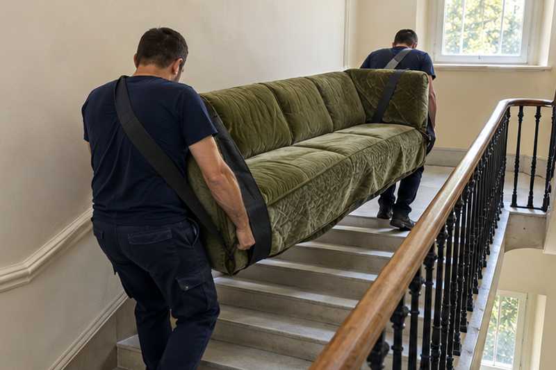 Canapé en velours tilleul porté à hauteur de hanche dans les marches